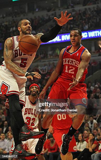 Evan Turner of the Philadelphia 76ers leaps to pass around Carlos Boozer of the Chicago Bulls in Game Five of the Eastern Conference Quarterfinals...