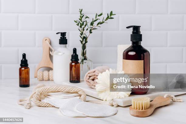 bottles of shampoo, soap, shower gel, moisturizer, serum, massage brushes, cotton pads for makeup remover. showcase with a stage for products, mockup design - duschgel nobody stock-fotos und bilder
