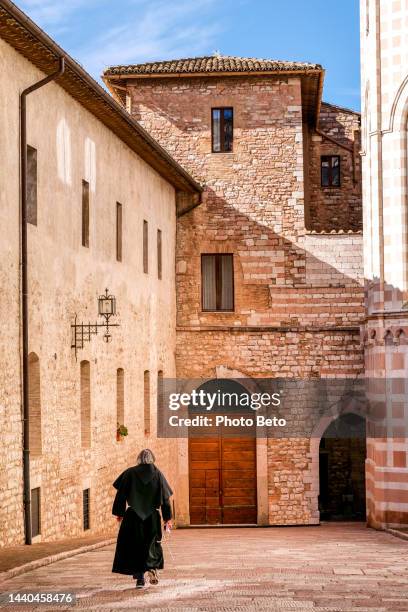 un fraile franciscano camina hacia el sacro convento en la ciudad medieval de asís - habit clothing fotografías e imágenes de stock