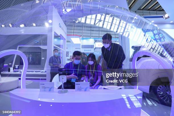 Staff member demonstrates a vehicle infotainment system at a booth of Vivo Communication Technology Co. Ltd during the Light of Internet Expo, part...