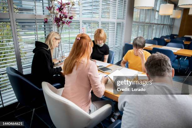 adult students learning together at a refugee educational centre - refugee facility stock pictures, royalty-free photos & images