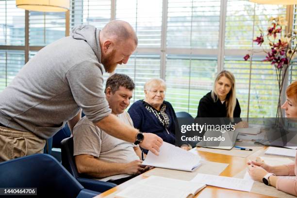 a community care giver volunteering at a refugee learning centre - student visa stockfoto's en -beelden