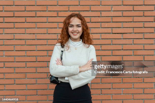 young woman smiling in front of the camera - oranje haar stockfoto's en -beelden