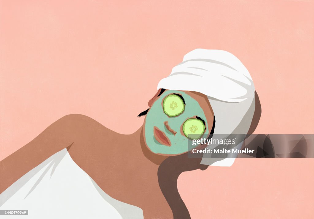 Woman relaxing, enjoying spa facial with cucumbers