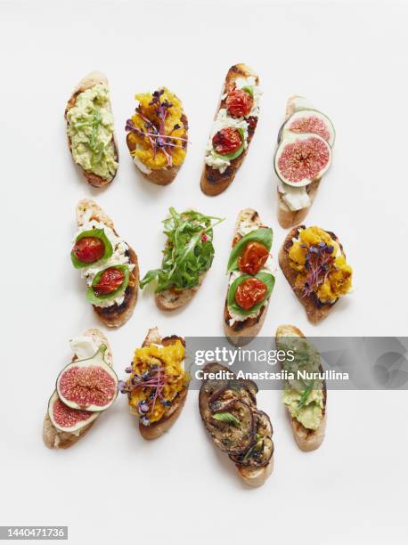 still life variety fruit and vegetable toast appetizers on white background - crostini stock pictures, royalty-free photos & images