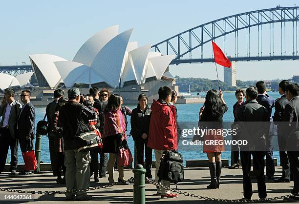 Group of Asian tourists arrive to have their photograph taken in front of the Sydney Opera House and Harbour Bridge, in this photo taken on May 8,...