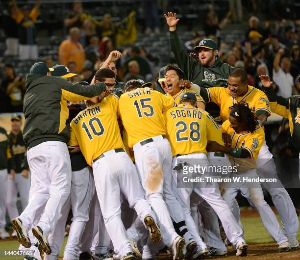 Brandon Inge of the Oakland Athletics gets smothered by his teammates after he hits a walk off grand-slam home run in the ninth inning to defeat the...