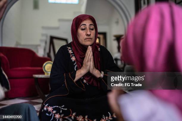 muslim women praying at home - lebanese ethnicity stock pictures, royalty-free photos & images
