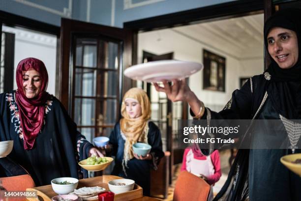 islamic family arranging table and serving food at home - lebanese ethnicity stock pictures, royalty-free photos & images