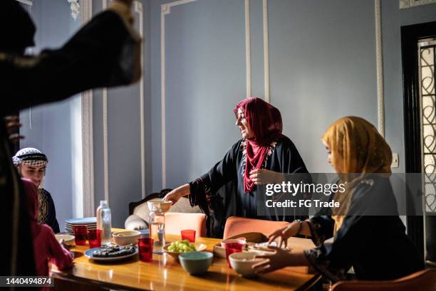 islamic family arranging table and serving food at home - lebanon concept stockfoto's en -beelden