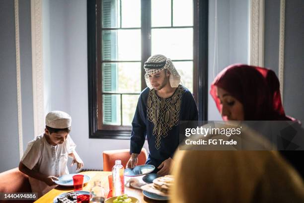 islamic family arranging table and serving food at home - lebanese ethnicity stock pictures, royalty-free photos & images