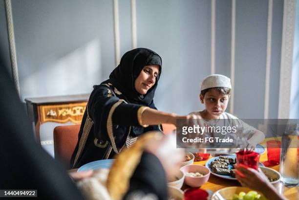 家で一緒に昼食をとるイスラムの家族 - ドルマデス ストックフォトと画像