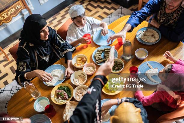 high angle view of a islamic family having lunch together at home - ramadan giving stockfoto's en -beelden