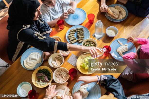 vista de alto ángulo de una familia islámica almorzando juntos en casa - arab family eating fotografías e imágenes de stock