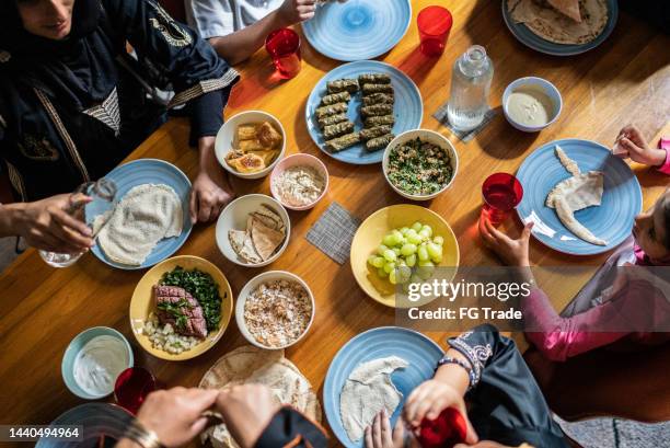 visão de alto ângulo de uma família islâmica almoçando juntos em casa - utensílio de cozinha equipamento doméstico - fotografias e filmes do acervo