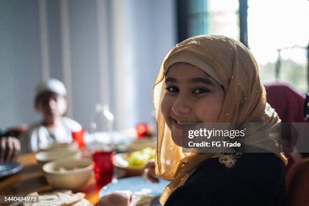 家で家族と昼食をとるかわいい女の子のポートレート - 西アジア民族 ストックフォトと画像