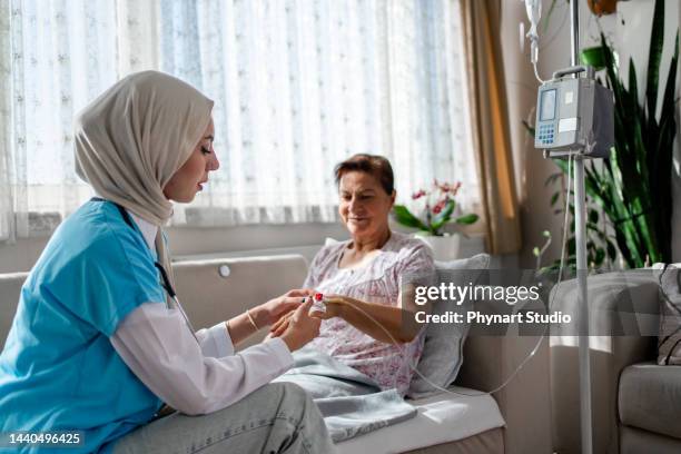 muslim woman health  visitor and a woman during home - arabische muster stockfoto's en -beelden