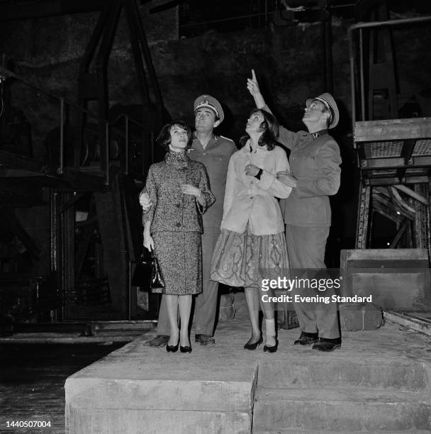 American actor Gregory Peck and British actor David Niven show their wives Veronique Peck and Hjordis Genberg around the film set of 'The Guns of...