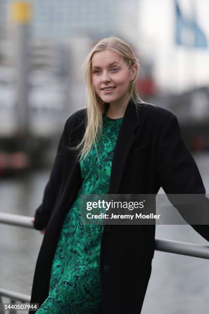 Lil Paulin seen wearing a green patterned long dress and a black long coat on November 08, 2022 in Hamburg, Germany.