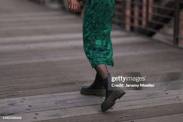 Lil Paulin seen wearing a green patterned long dress and black and dark green leather boots by Copenhagen Studios on November 08, 2022 in Hamburg,...