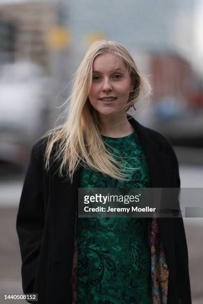 Lil Paulin seen wearing a green patterned long dress and a black long coat on November 08, 2022 in Hamburg, Germany.