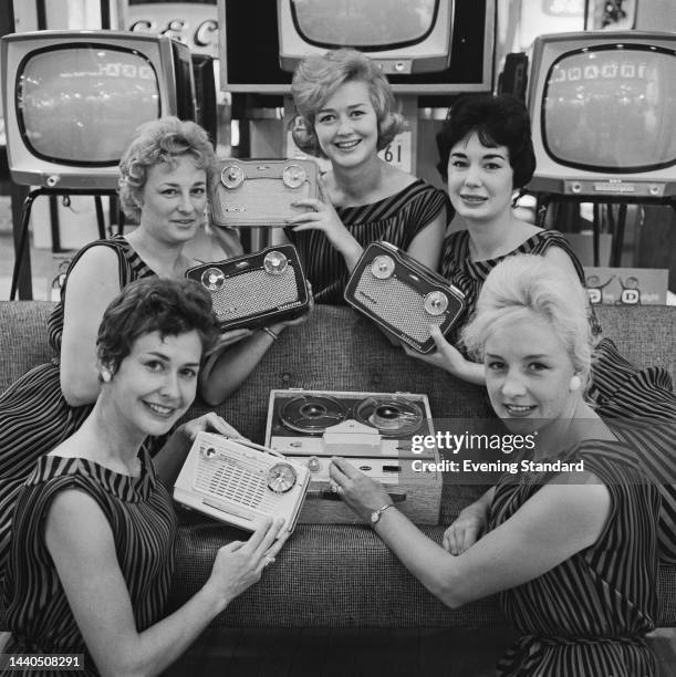Models posing with portable radios and a tape recorder at the National Radio and Television Show at Earls Court in London on August 23rd, 1960.