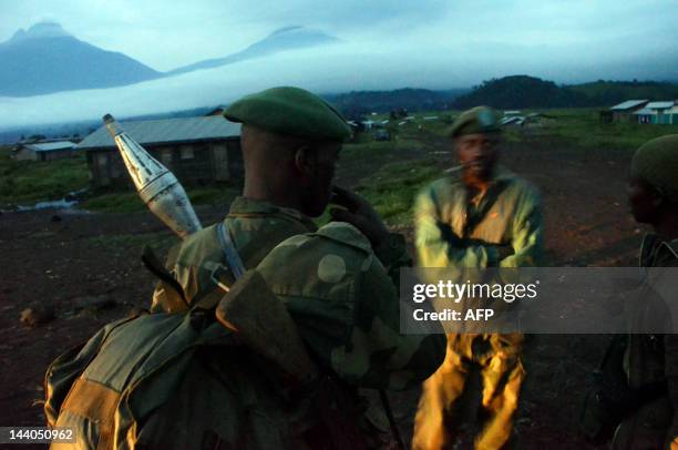 Congolese army soldiers stand on May 8, 2012 in the deserted town of Kibumba near the Virunga national park on the border with Rwanda after its...