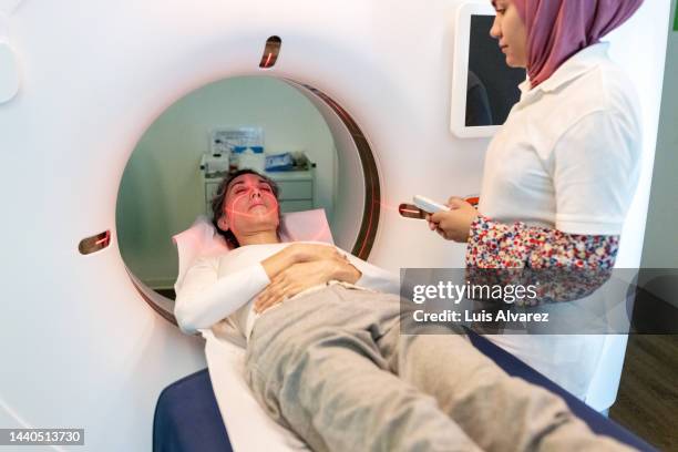 woman patient and medical technician at the computer tomography getting a scan - cat scan machine stock pictures, royalty-free photos & images