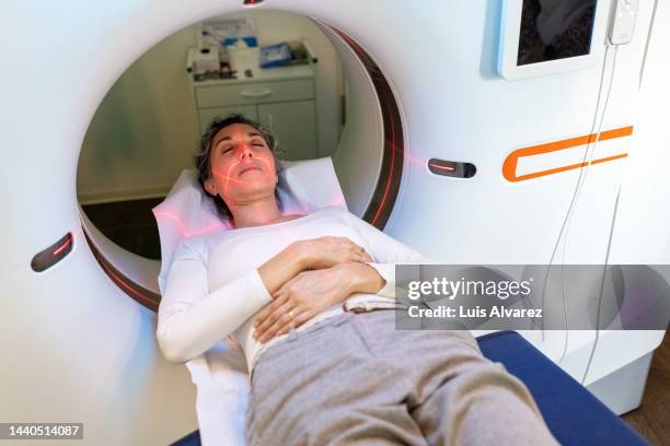 mature hispanic woman going through mri scanner - body scans stock-fotos und bilder