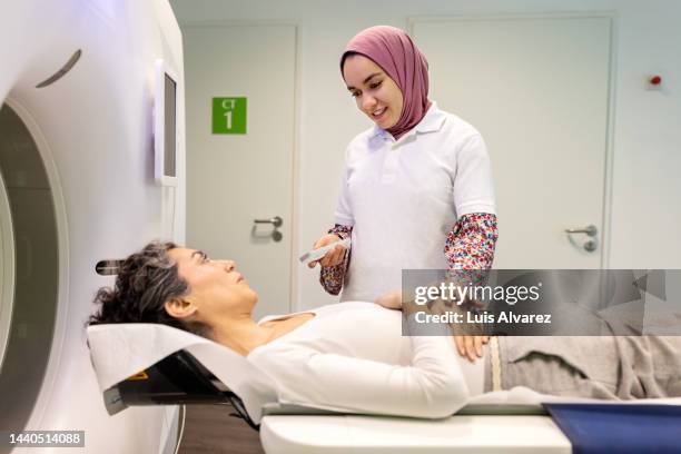 mature woman being comforted by a female doctor before mri scan - huvudduk bildbanksfoton och bilder