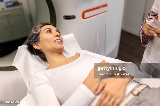 woman patient undergoing cat scan at hospital - body scans stock-fotos und bilder