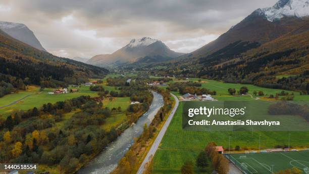 aerial view of the football field in the town with scenic mountain landscape in norway - romsdal in norway stockfoto's en -beelden