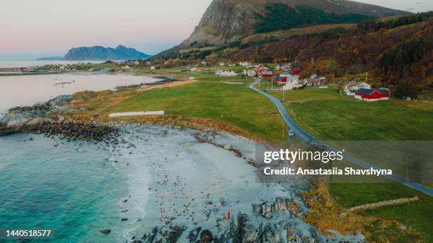 aerial view of woman and man having picnic at the beach admiring sunset  with scenic view in norway - scandinavia picnic stock pictures, royalty-free photos & images