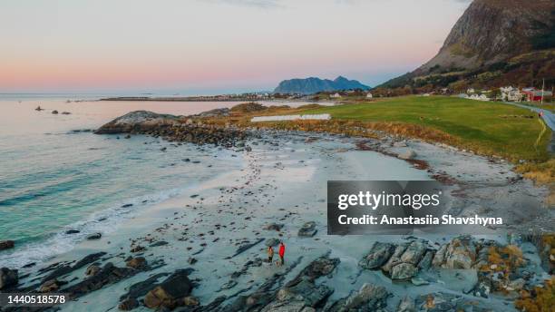 aerial view of woman and man having picnic at the beach admiring sunset  with scenic view in norway - romsdal in norway stockfoto's en -beelden