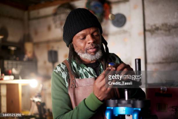 jewellery, design and black man working in workshop with tools to repair, create and make accessories. creative designer, jeweler and man from south africa work on gold ring in diamond production - jeweller tools stock pictures, royalty-free photos & images
