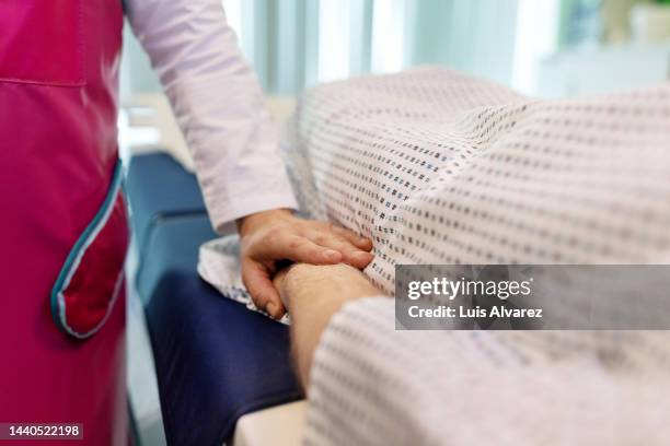 close-up of radiologist consoling man in mri scan room - radioterapia imagens e fotografias de stock