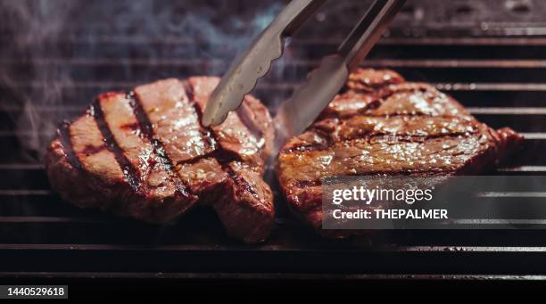 flipping sirloin steaks on the grill - lombo de vaca imagens e fotografias de stock