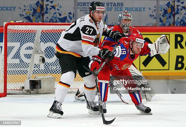 Denis Kokarev of Russia battles for position with Kevin Lavallee of Germany in front of the net during the IIHF World Championship group S match...