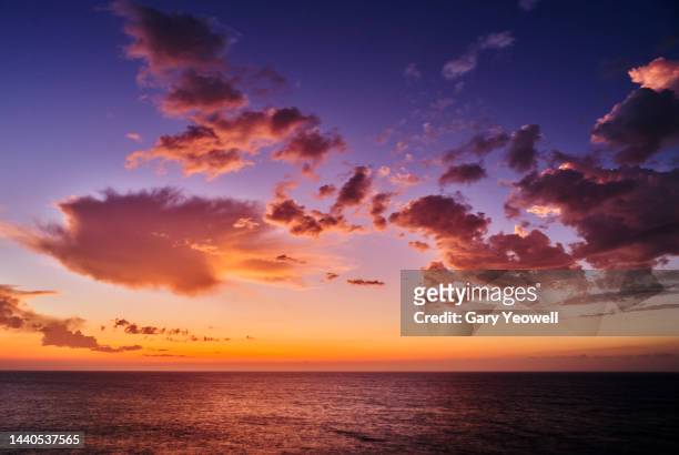 vivid colour clouds over the sea at sunset - sunset stock pictures, royalty-free photos & images