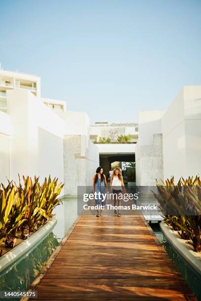 wide shot of family walking on boardwalk at luxury tropical resort - luxury girl stock pictures, royalty-free photos & images
