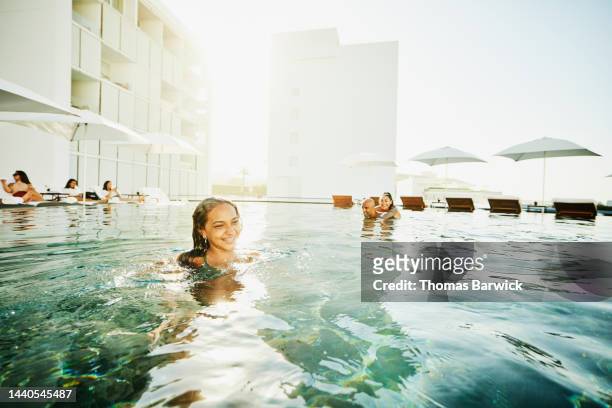 wide shot of girl relaxing in pool with parents at tropical resort - mother with daughters 12 16 stock-fotos und bilder
