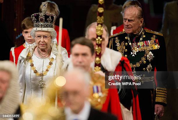 Queen Elizabeth II, wearing the Imperial State Crown, and Prince Philip, Duke of Edinburgh proceed through the Royal Gallery in the Palace of...
