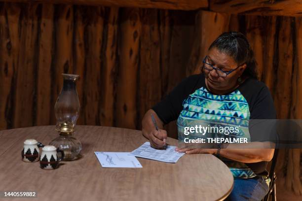 glückliche seniorin zu hause mit ihrer briefwahl - indigenous american culture stock-fotos und bilder