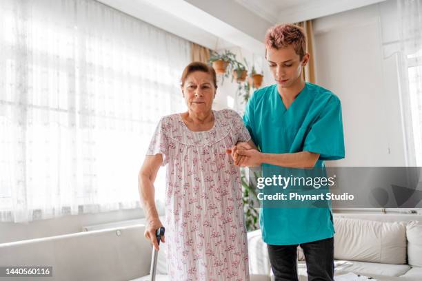 caregiver helping senior woman patient walking - nursing assistant stock pictures, royalty-free photos & images