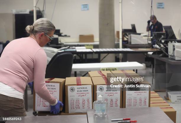 An election worker places a box of scanned ballots on a pallet at the Maricopa County Tabulation and Election Center on November 10, 2022 in Phoenix,...