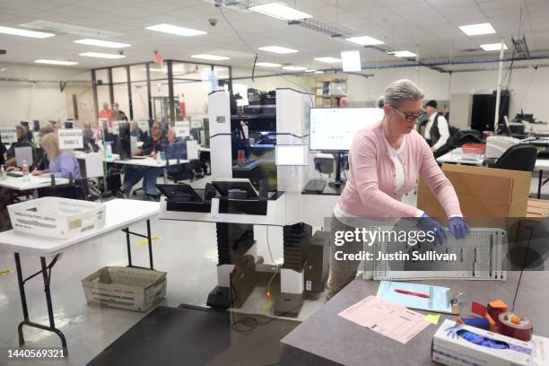 An election worker scans ballots at the Maricopa County Tabulation and Election Center on November 10, 2022 in Phoenix, Arizona. Ballots continue to...