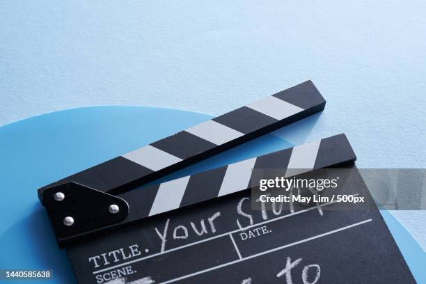 clapper board with text your story against blue background - advisory board stockfoto's en -beelden