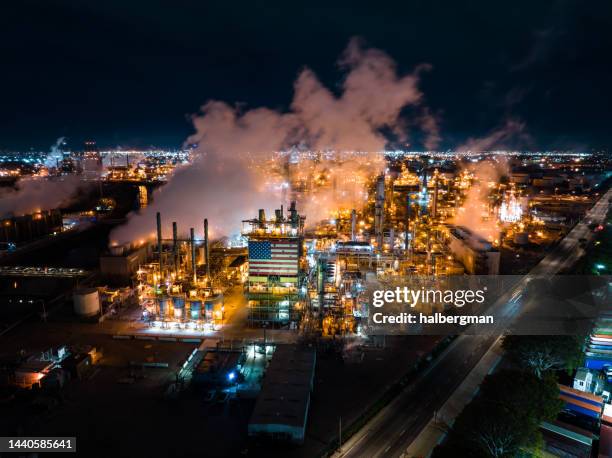 aerial view of massive refinery complex with american flag at night - carson california stock pictures, royalty-free photos & images