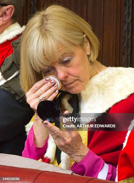 Woman touches up her make-up as she waits to hear Britain's Queen Elizabeth II read the Queen's Speech in the Chamber of the House of Lords in the...