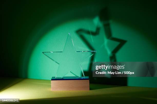 trophy crystal against green and yellow background,malaysia - business awards ceremony stock pictures, royalty-free photos & images